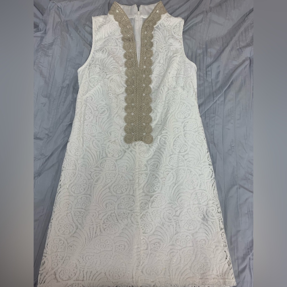 White lace dress with gold braiding on the front plaque